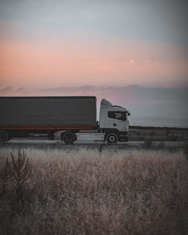 Freight truck traveling along a highway at dusk